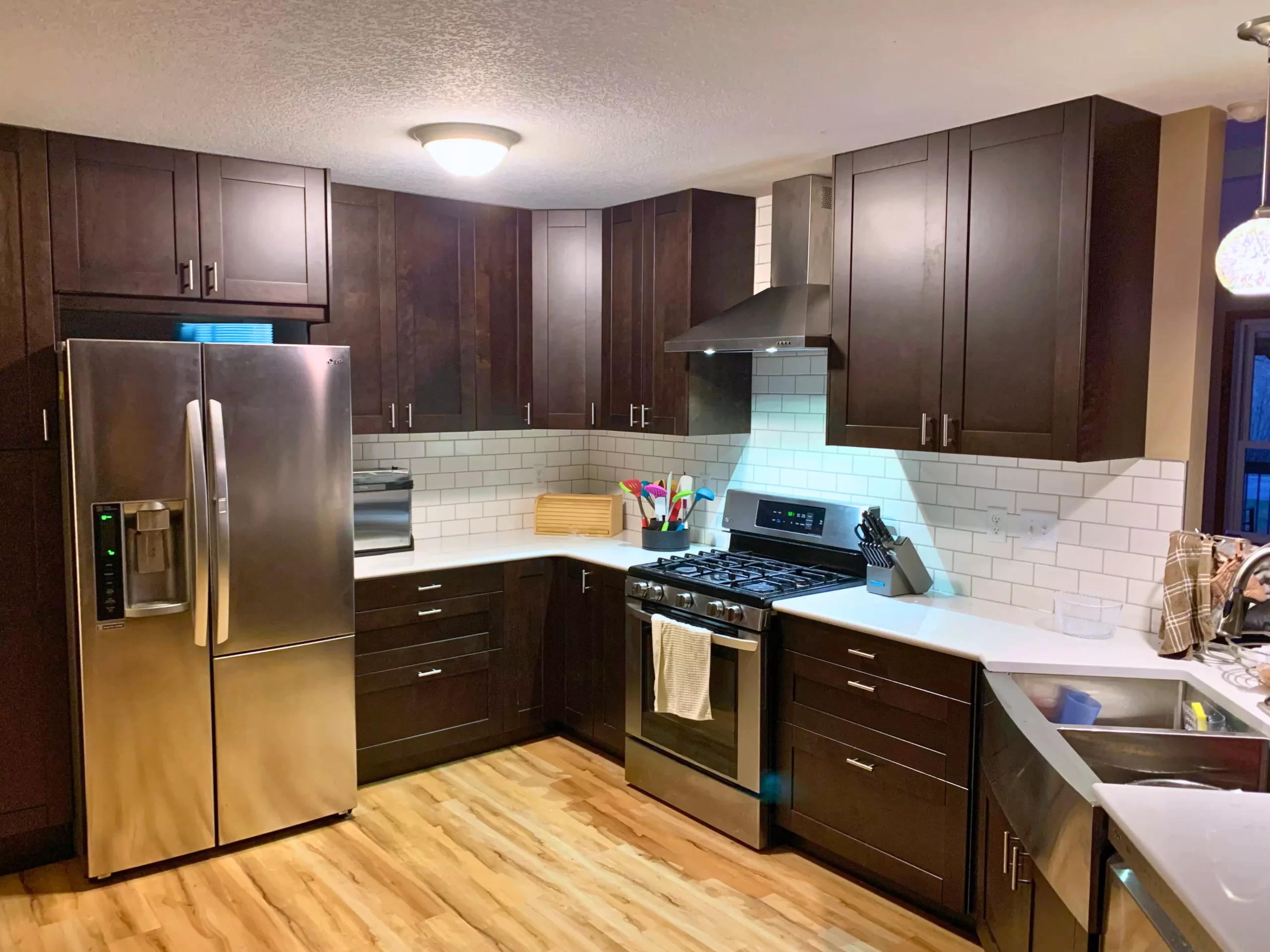 A beautiful kitchen with chestnut cabinets, granite countertops, and white subway tile backsplash.